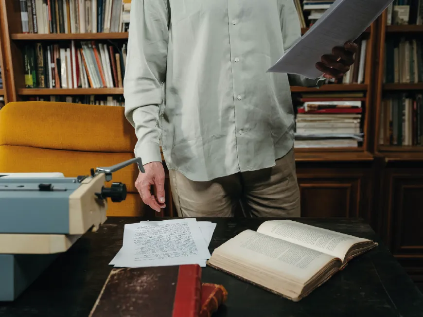 Homme-lisant-des-fiches-avec-un-bouqin-sur-une-table