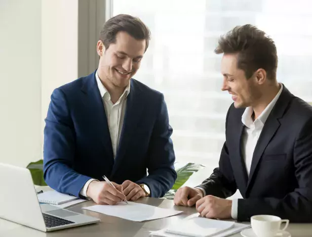 handsome-businessman-signing-contract-with-partner