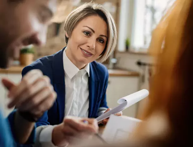 smiling-insurance-agent-going-through-paperwork-communicating-with-her-clients-during-meeting